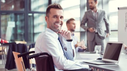 Lächelnder Mann im Rollstuhl.